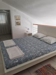 um quarto com uma cama grande e um cobertor azul em Apartmani Vrančić em Mandre