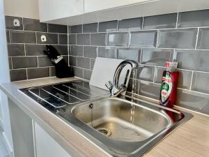a kitchen counter with a sink and a fire extinguisher at Cosy 1-Bedroom Apartment Briton Ferry, Neath Port Talbot in Briton Ferry