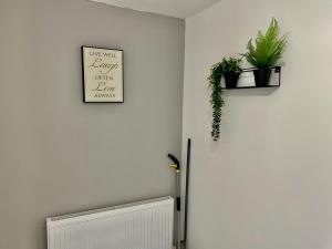 a room with a radiator and plants on the wall at Cosy 1-Bedroom Apartment Briton Ferry, Neath Port Talbot in Briton Ferry