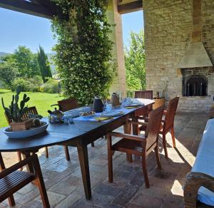 długi drewniany stół i krzesła na patio w obiekcie Agriturismo Molleone w mieście Cagli