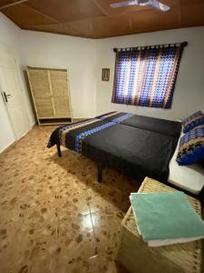 a bedroom with a bed and a window and a couch at TRANQUIL RESORT HOTEL in Brusubi