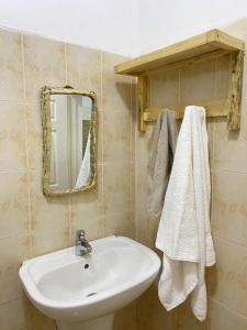 uma casa de banho com um lavatório branco e um espelho. em TRANQUIL RESORT HOTEL em Brusubi