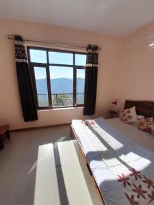 um quarto com uma cama e uma grande janela em Mountain and peace em Shimla