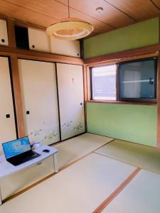 ein leeres Zimmer mit einem Laptop auf dem Tisch in der Unterkunft Shonan no Oka no Villa - Vacation STAY 24013v in Fujisawa