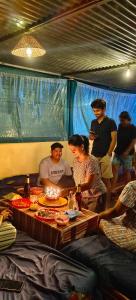 eine Gruppe von Menschen, die um einen Tisch mit einem Kuchen mit Kerzen stehen in der Unterkunft Jungle by sturmfrei Gokarna in Gokarna