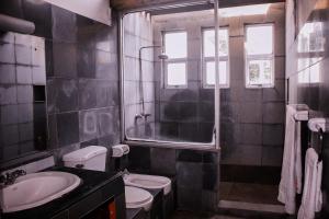 uma casa de banho com um lavatório, um WC e uma janela. em Villa Inavni em Talawatugoda