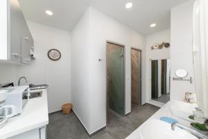 cocina blanca con lavabo y ducha en Serenita premiums apartment 3, en Agios Nikolaos