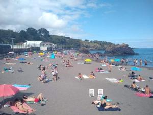 a large group of people on a beach at Pousada da Vila in Vila Franca do Campo