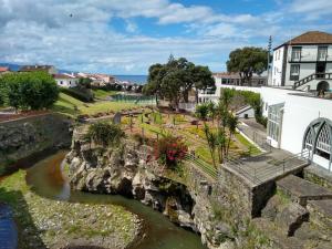 a view of a river with a bridge and buildings at Pousada da Vila in Vila Franca do Campo