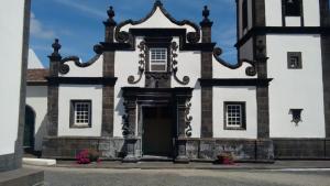 an old white building with a door and flowers at Pousada da Vila in Vila Franca do Campo