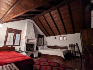 a living room with two beds and a fireplace at Traditional Guesthouse Lanari in Livádion