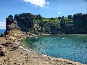 a group of people on the shore of a body of water at Pousada da Vila in Vila Franca do Campo