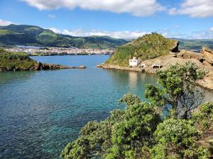 a view of a large body of water with mountains at Pousada da Vila in Vila Franca do Campo