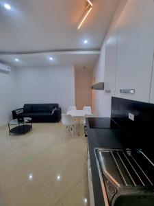 een keuken en een woonkamer met een bank en een tafel bij Bass Apartment in Pula