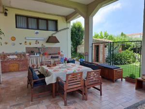 eine Terrasse mit einem Tisch und Stühlen sowie eine Küche in der Unterkunft Triskelion in Nunziata