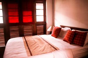 1 dormitorio con 1 cama con sábanas y almohadas blancas en Villa Inavni en Talawatugoda