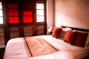 a bedroom with a bed with white sheets and pillows at Villa Inavni in Talawatugoda