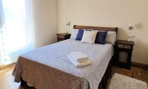 a bedroom with a bed with towels on it at Piso "Al Norte" Luanco Terraza Parking WI-FI in Luanco