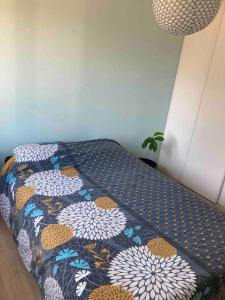 a bed with a quilt on it in a room at La maison du bonheur in Biscarrosse