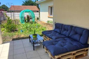 a large blue couch sitting on a patio at La maison du bonheur in Biscarrosse +3 photos