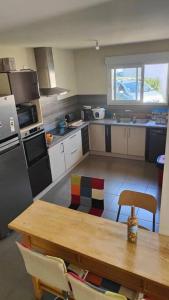 a kitchen with a wooden table and a table and a wooden table at La maison du bonheur in Biscarrosse