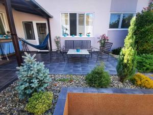 a patio with chairs and a table in a yard at Sombor 19 Central Apartment in Sombor