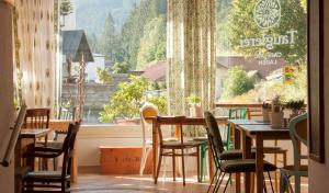 un restaurante con mesas y sillas y una gran ventana en Tauglerei Doppelzimmer Bergamotte en Sankt Koloman