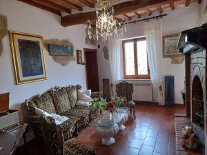 salon z kanapami i żyrandolem w obiekcie Il Casale degli Artisti w mieście Ravigliano