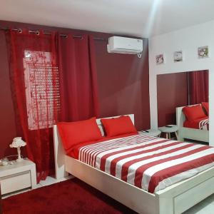 1 dormitorio con paredes rojas y 1 cama con almohadas rojas en Location chambres Mtsapéré Maevantana sur Mamoudzou Mayotte chez Zam, en Mamoudzou