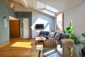 a living room with a blue couch and a skylight at ArtSquare Fragola Apartments in Kraków