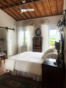 Un dormitorio con una gran cama blanca y una ventana en Casa Domenico, en Spello