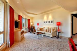 ITC Maratha, a Luxury Collection Hotel, Mumbai في مومباي: غرفة معيشة مع أريكة وتلفزيون