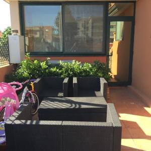 クアルトゥ・サンテーレナにあるAtene Apartmentの植物の置かれたポーチに座る黒いソファ