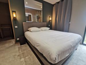 索泰爾內的住宿－Villa Lodge Sauternes Darroze，卧室配有一张带白色床单和枕头的大床。