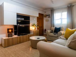 ein Wohnzimmer mit einem Sofa und einem TV in der Unterkunft Amigos I at Veramar 6 in Vera