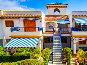 un edificio con balconi bianchi e blu e una scala di Amigos I at Veramar 6 a Vera