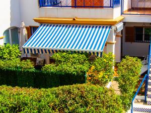 un edificio con toldo y arbustos azules y blancos en Amigos I at Veramar 6, en Vera