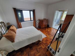 a bedroom with a bed and a wooden floor at Pousada da Vila in Vila Franca do Campo