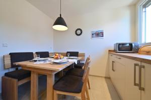 cocina con mesa de madera con sillas y microondas en Haus Kaulitzki, en Wasserburg