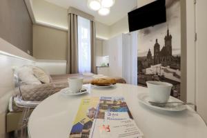 Biały stół z dwoma kubkami i magazynem w obiekcie Apartamenty Podwale w Krakowie