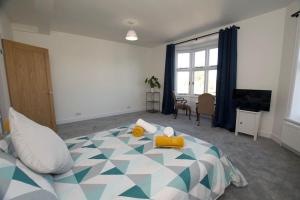 a bedroom with a large bed with a blue at Beautiful large 3-bed coastal flat with parking. in Frinton-on-Sea