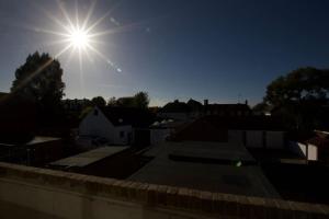 Un sole che splende nel cielo sopra una città di Beautiful large 3-bed coastal flat with parking. a Frinton-on-Sea