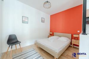 a bedroom with a bed with an orange wall at Chez Yvette 1 Ground floor Near the sea in Leucate