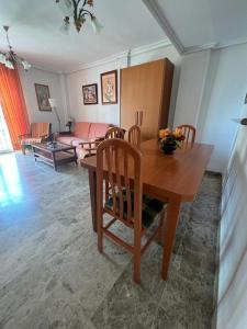 un soggiorno con tavolo e sedie in legno di Apartamentos COZYNNS II a Torremolinos