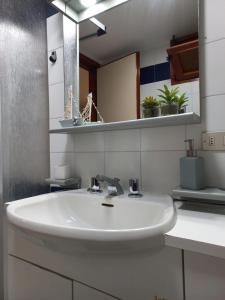 y baño con lavabo blanco y espejo. en Monolocale a due minuti dal mare IUN R4225, en Marina di Portisco