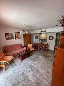 a living room with a couch and a table at Apartamentos COZYNNS II in Torremolinos
