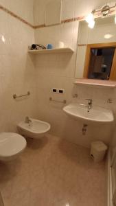 Baño blanco con lavabo y aseo en Apartments Gana, en La Villa