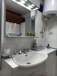 y baño con lavabo blanco y espejo. en Monolocale a due minuti dal mare IUN R4225 en Marina di Portisco