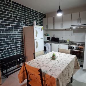 a kitchen with a table and a white refrigerator at Happy Guest Apart 53 in Ushuaia +6 photos