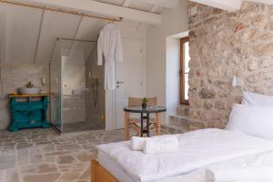 a bedroom with a shower and a bed and a table at Hotel Restoran Humsko in Trebinje